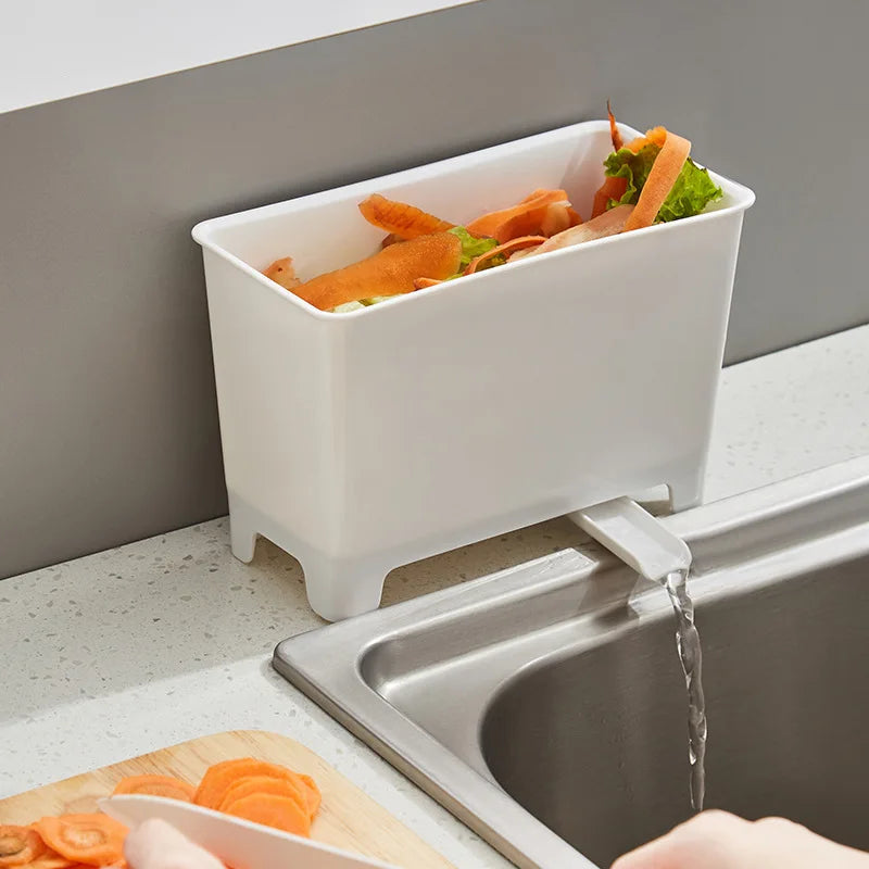 White food waste bin draining at the side of a sink