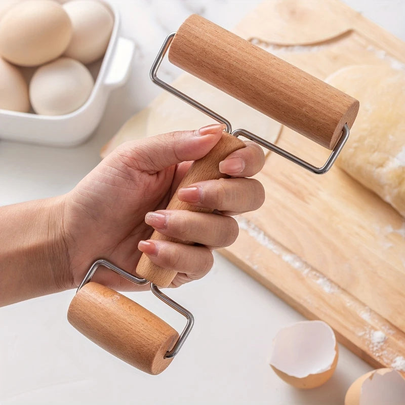 Hand holding a wooden double-ended pastry roller