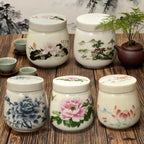 Four painted ceramic egg coddlers with lids on a wooden table