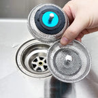 Hand lifting a mesh strainer out of a sink plughole
