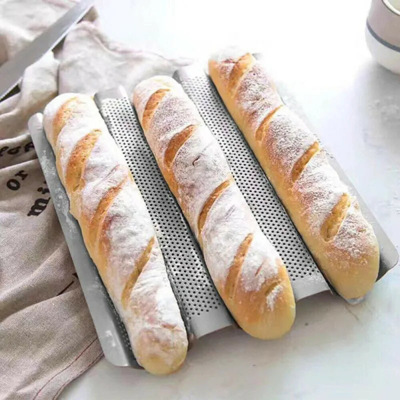 Freshly baked baguettes on a perforated baguette tray