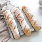 Freshly baked baguettes on a perforated baguette tray