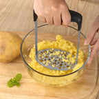 Mashing potatoes in a glass bowl