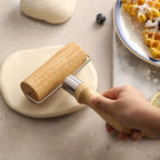 Wooden handheld pastry roller flattening dough