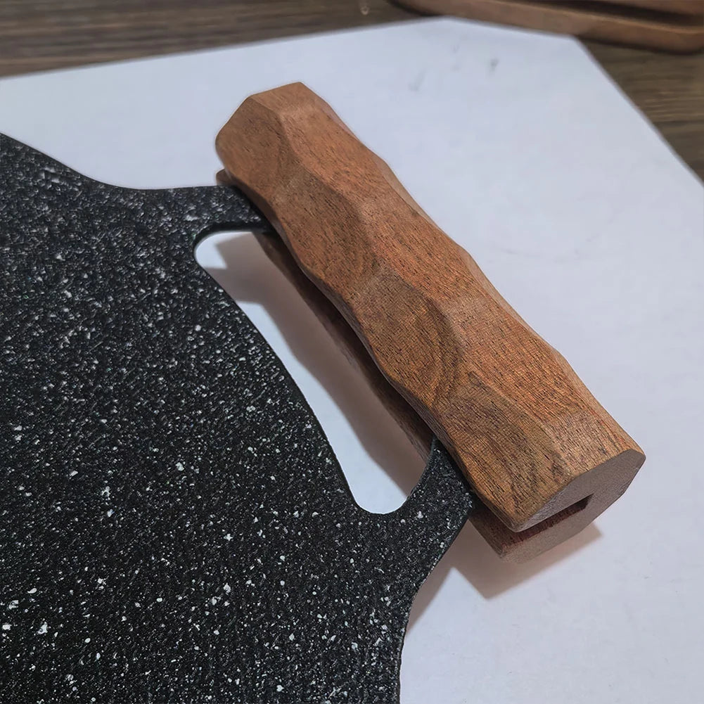 Wooden grip fitted to the handle of a black pan