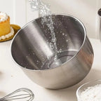 Deep stainless steel mixing bowl on a baking counter