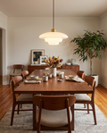 White glass pendant light styled above a dining table