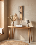 Slim rectangular wood-frame wall clock styled above a console table
