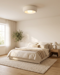 Minimalist circular flush-mount ceiling lamp styled in a bright bedroom