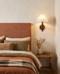 Nordic wooden wall sconce styled beside a bed